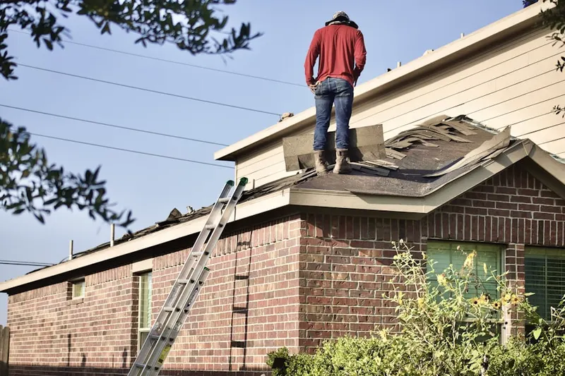 Professional roofer working on a residential roof in Sealy